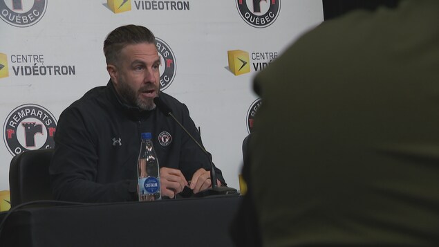 Un homme s'adresse aux médias lors d'une conférence de presse. 