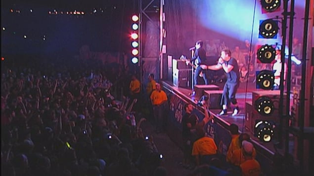 Le groupe Simple Plan chante sur une scène.