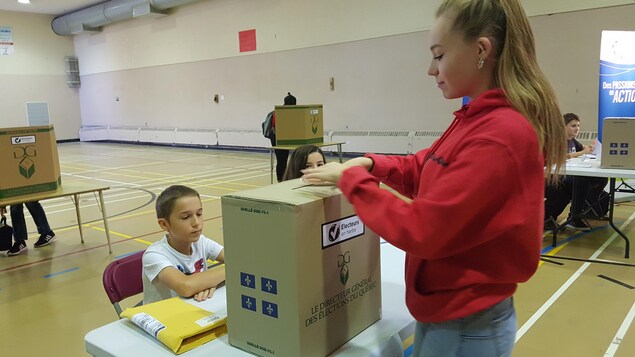Une élève d'une école secondaire de Québec dépose son bulletin dans une urne à l'occasion d'une simulation électorale