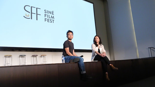 Sina Carlo Mendoza at Justine Abigail Yu nakaupo sa stage habang mababasa sa likod ang Sine Film Fest.