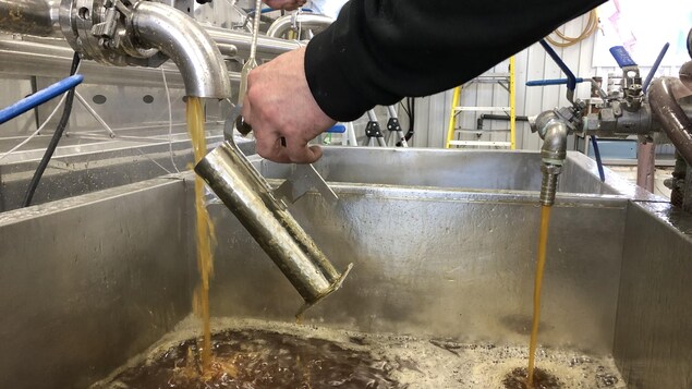 Du sirop d'érable qui coule d'un robinet.