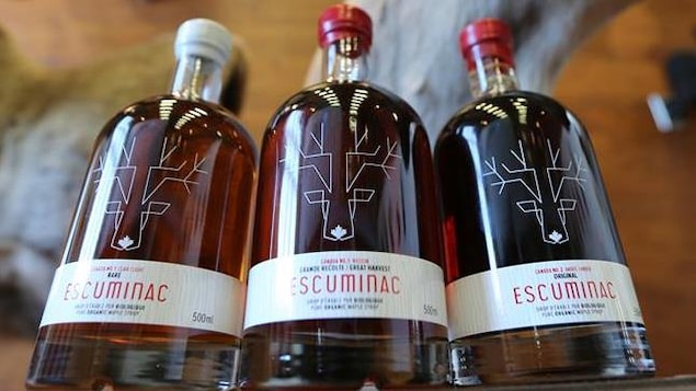 Trois bouteilles de sirop d'érable remplies. Trois bouteilles de sirop d'érable remplies.