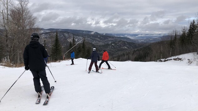 Des skieurs au sommet d'une montagne.