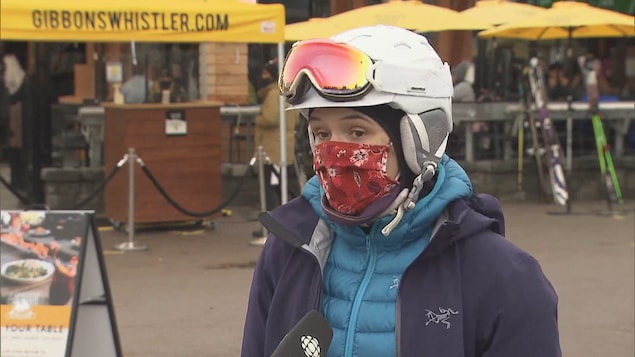 Une skieuse avec un masque en entrevue.