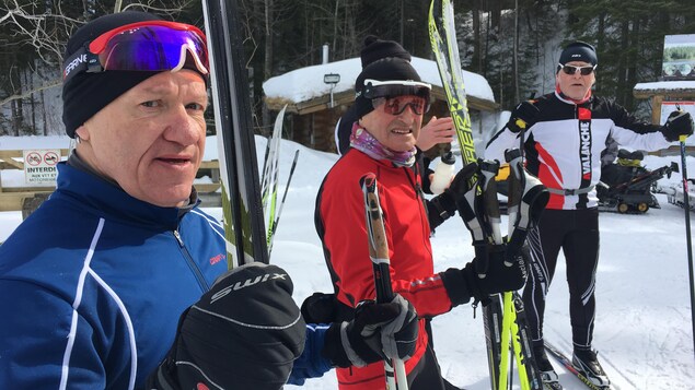 Trois hommes avec leurs skis de fond Trois hommes avec leurs skis de fond