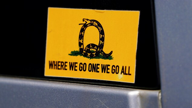 Un autocollant de QAnon sur lequel on peut lire le slogan utilisé par l'organisation : « Quand un de nous y va, nous y allons tous. » 