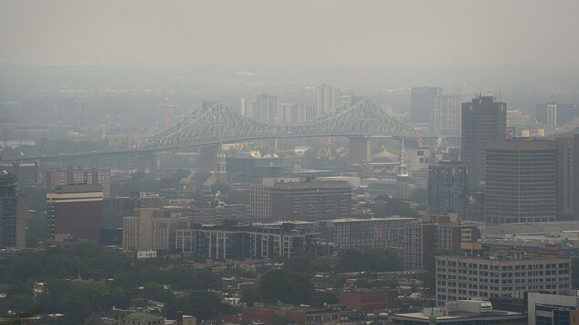 Une vue du pont Jacques-Cartier voilée par la fumée.