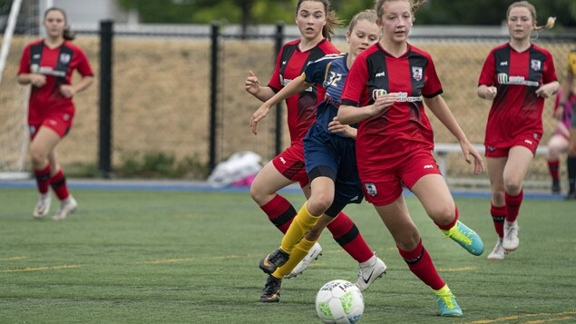 Des joueuses de soccer luttent pour l'obtention du ballon.