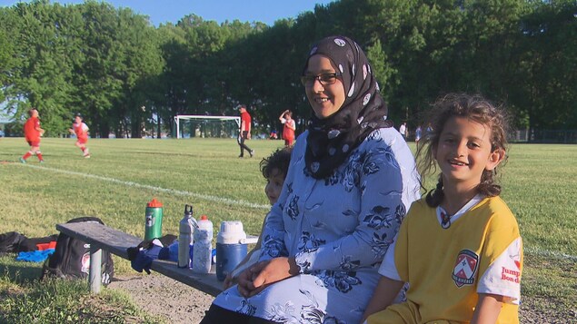 La famille, tout sourire, devant un terrain de soccer La famille, tout sourire, devant un terrain de soccer