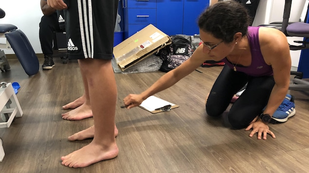 Anne-Laure Ménard, étudiante au postdoctorat en biomécanique, mesure les pieds de deux jeunes joueurs de soccer dans le cadre d'une étude.