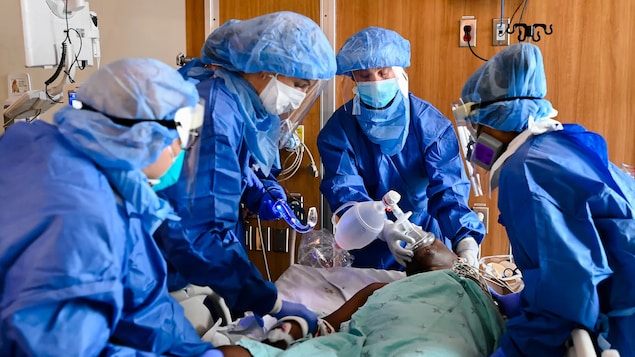 Des infirmières et des médecins s'affairent autour d'un patient qui reçoit de l'oxygène.