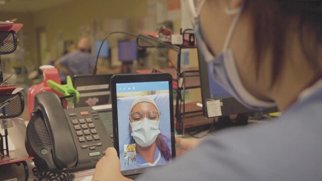 Des membres du personnel de santé communiquent via des tablettes électroniques.