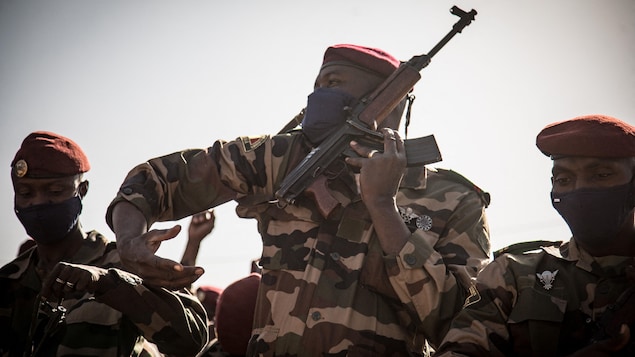 Un soldat attache son arme à Bamako.