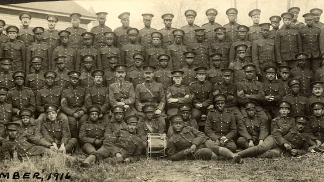 Des hommes en tenue militaire poses pour une photo.