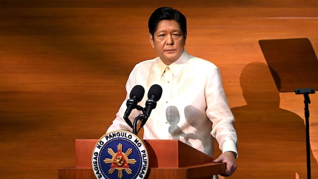 Ferdinand Marcos Jr. nasa harap ng mikropono at nakatayo sa podium na may sagisag ng pangulo ng Pilipinas. 