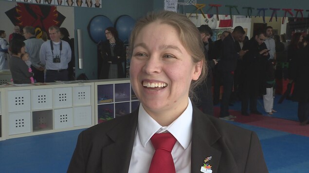 La femme tout sourire est dans une salle d'entraînement d'une école de taekwondo La femme tout sourire est dans une salle d'entraînement d'une école de taekwondo