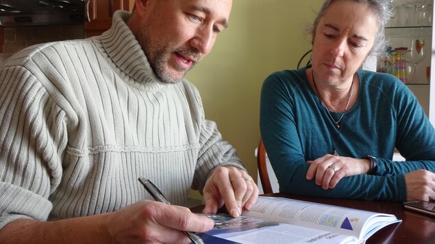 Sophie Arsenault et André Pineault consultent des livres sur les grandes traversées en voilier. Sophie Arsenault et André Pineault consultent des livres sur les grandes traversées en voilier.