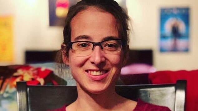 Portrait en couleur de l'autrice Sophie René de Cotret. Elle porte des lunettes et un chandail rouge.