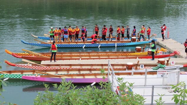 Les participants embarquent dans un bateau-dragon Les participants embarquent dans un bateau-dragon