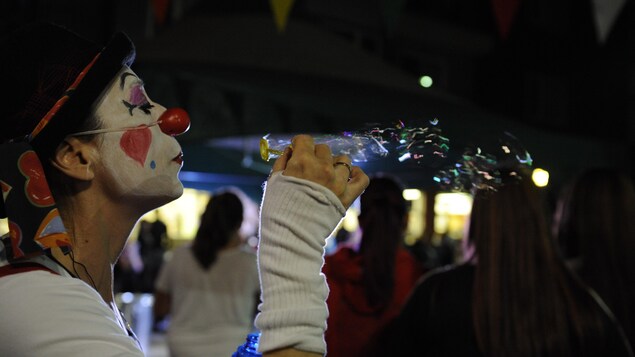 Un clown souffle pour créer des bulles dans l'air Un clown souffle pour créer des bulles dans l'air