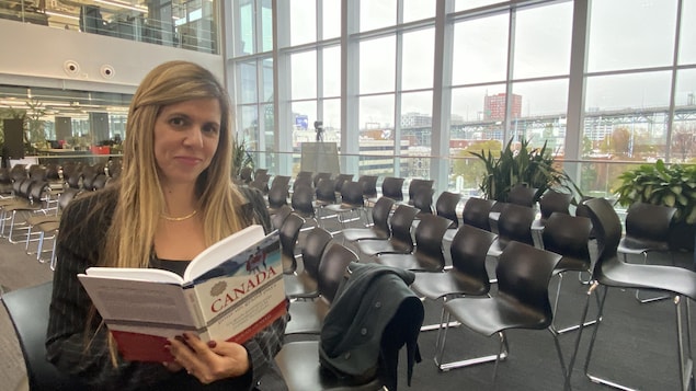 Une femme tenant un livre dans la main.