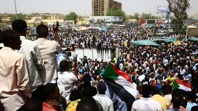 Une foule monstre est rassemblée dans un espace public au centre de Khartoum.