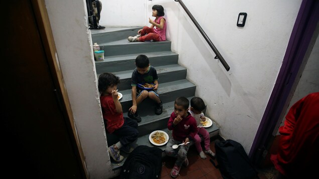 Des enfants mangent dans les escaliers d'une soupe populaire à Buenos Aires.