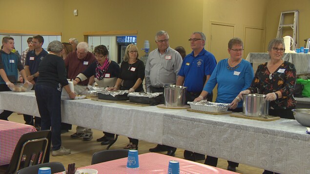Des bénévoles se préparent à servir la nourriture pour le souper paroissial de Notre-Dame-de-Lorette.