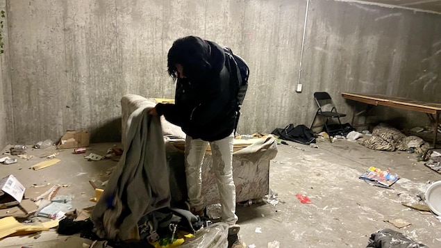 Entre quatre murs de béton, un divan décrépit et des déchets qui jonchent le sol, Jackie Riverain-Imbeault soulève une couverture qui recouvre un sac à dos.