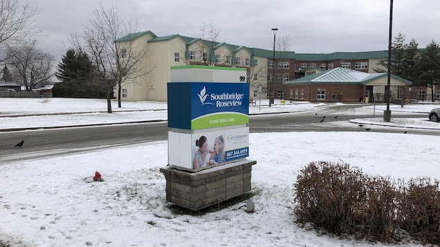 L'affiche extérieure du centre de soins de longue durée est devant l'établissement sur un terrain gazonneux couvert de neige.