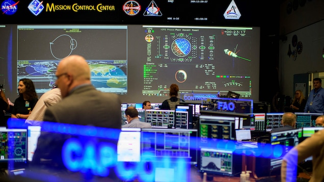 Des gens dans le centre de contrôle des missions du Johnson Space Centers. 