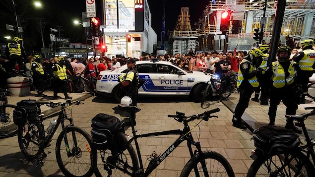 Des policiers du SPVM devant une foule au centre-fille.