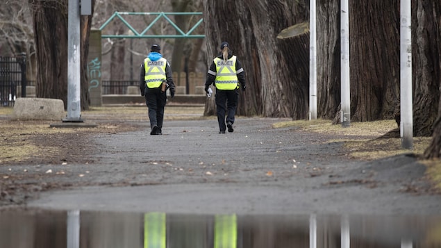 Deux cadets du SPVM marchent côte à côte dans un parc.