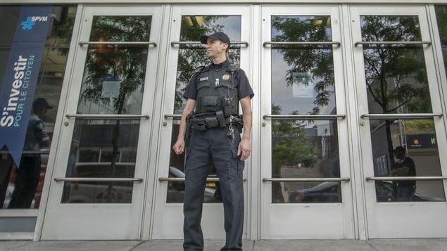 Un policier devant une porte d'entrée.