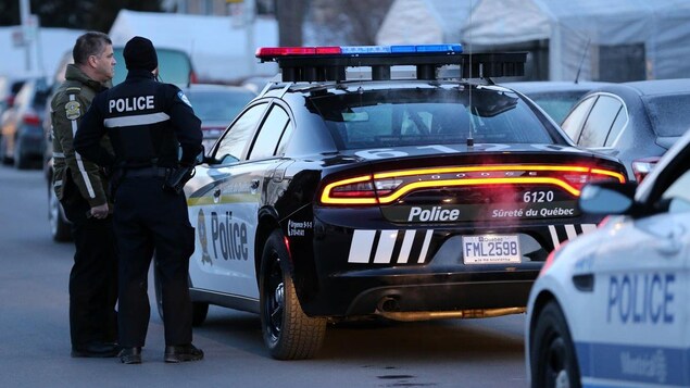 Des policiers discutent près d'une autopatrouille.