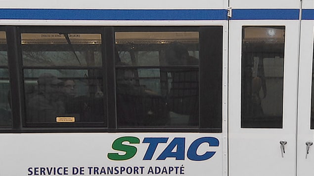 Un autobus du Service de transport adapté de la Capitale dans lequel prennent places plusieurs passagers.