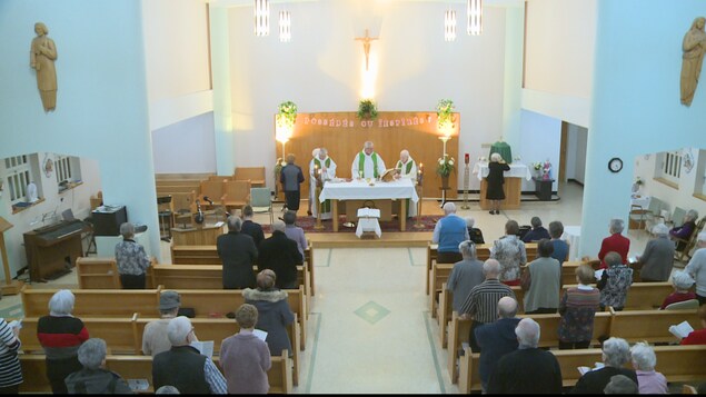 Une chapelle à moitié remplie de croyants lors d'une messe. Une chapelle à moitié remplie de croyants lors d'une messe.