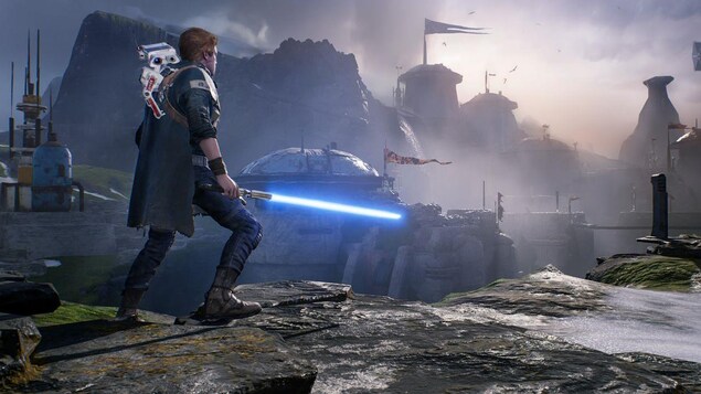 Un personnage de jeu vidéo tient un sabre laser dans un paysage post-apocalyptique. 