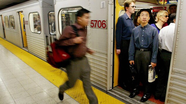 Un passager court et essaie d'entrer dans un wagon de métro.