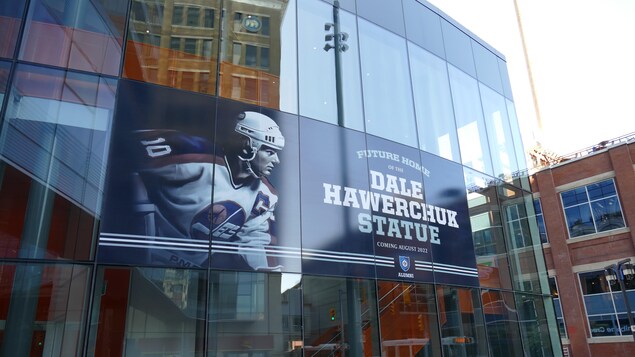 Une affiche annonçant la venue prochaine d'une statue en l'honneur de Dale Hawerchuk au Centre Canada Life.