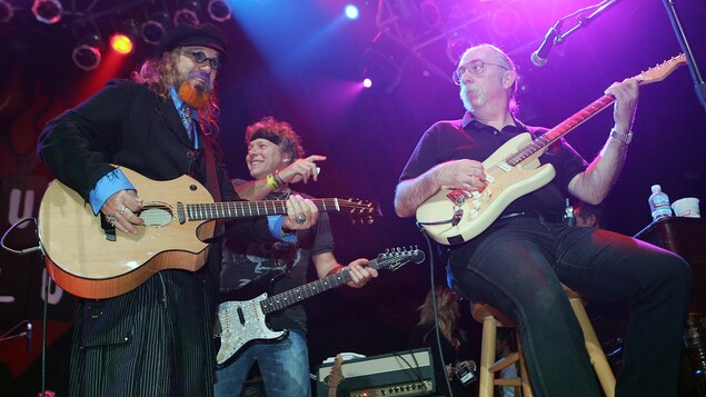 Les trois artistes jouent de la guitare sur scène. Les trois artistes jouent de la guitare sur scène.