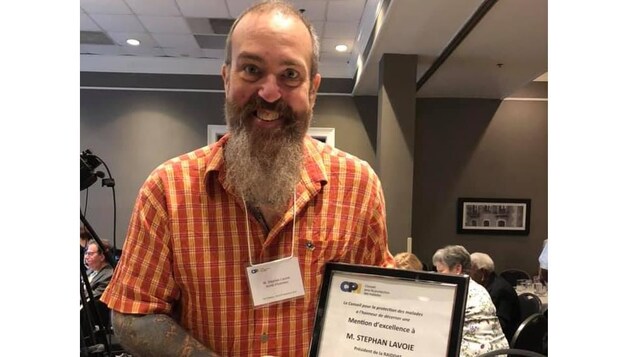 Stephan Lavoie pose avec son prix à la main.