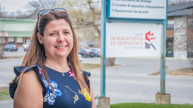 Stéphanie Patry pose pour une photo, à l'extérieur. Derrière elle se trouve une affiche du Centre de réadaptation en dépendance de l'Outaouais. Stéphanie Patry pose pour une photo, à l'extérieur. Derrière elle se trouve une affiche du Centre de réadaptation en dépendance de l'Outaouais.