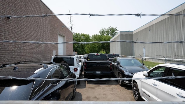 Cars parked behind barb wires.