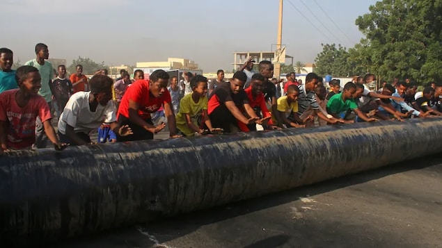Sudanese erect barricades as they protest against a military coup that overthrew the transition to civilian rule on Monday in the al-Shajara district in southern Khartoum.