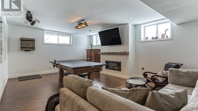 Un sous-sol aménagé avec une table de ping-pong