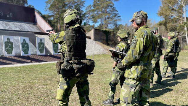 Arms in hand, a soldier aims at a target.