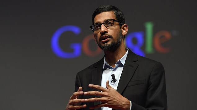 Le PDG de Google et d'Alphabet Sundar Pichai parle sur une scène devant le logo de Google.