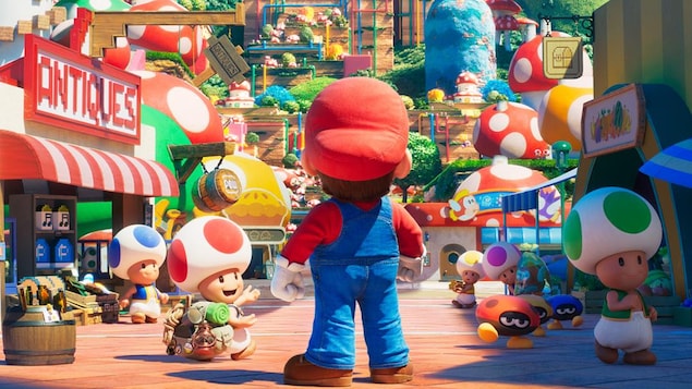 Dans une image d'animation avec de nombreux personnages, Mario, de dos, regarde devant lui.