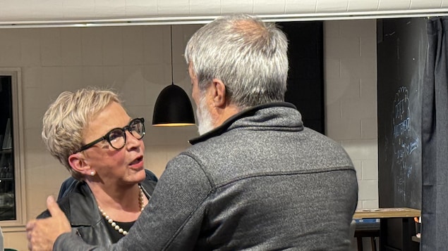 Suzanne Blais pleure dans les bras de deux femmes.